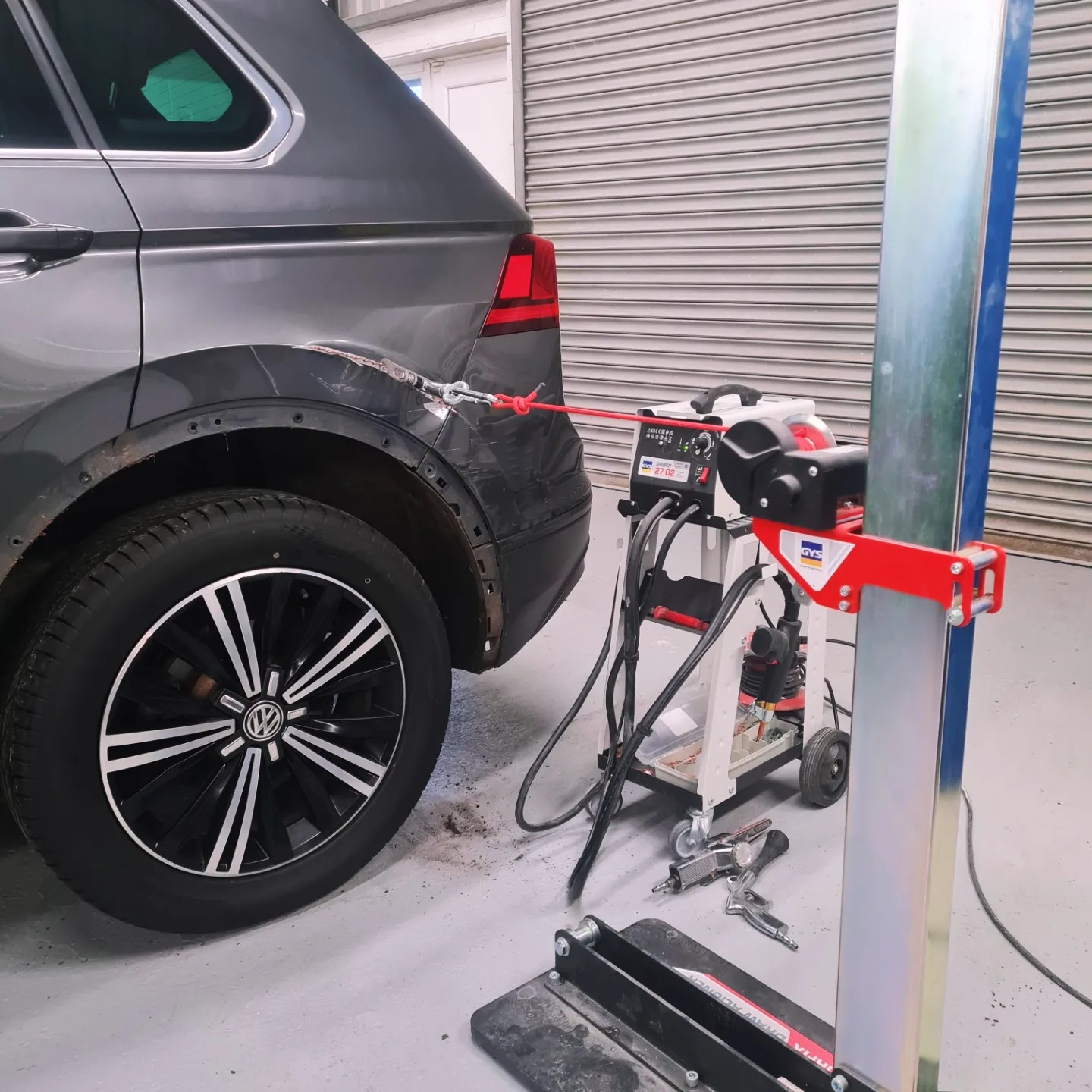 The same Tiguan in the workshop with a pulling rig attached to the rear arch